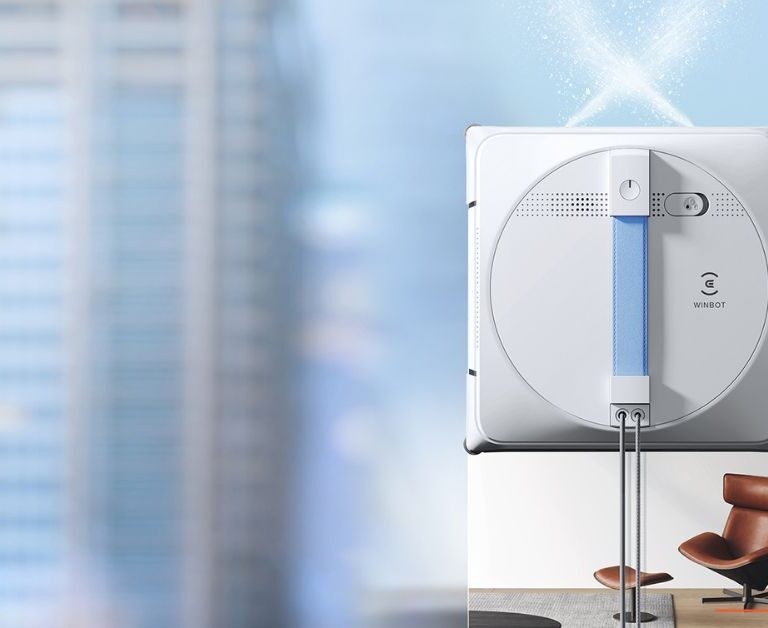 Moderni robot perač prozora sa automatskim raspršivačem vode tokom čišćenja visokih staklenih površina.